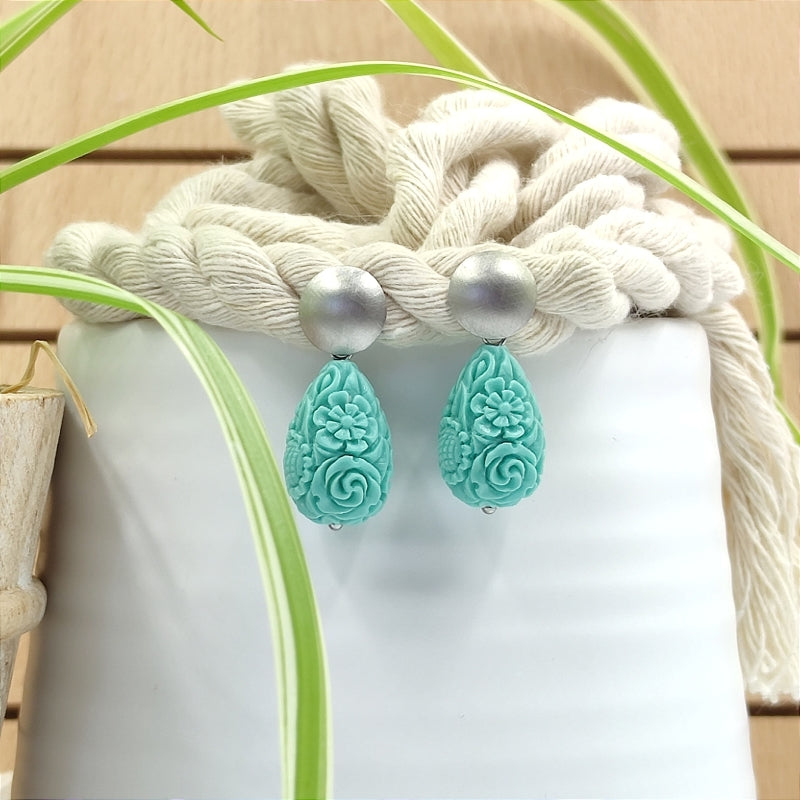 Die Lucy Tropfen-Ohrringe in türkis mit zartem Blumenmuster vereinen Eleganz & Tradition. Handgefertigt in Österreich, super verträglich & perfekt fürs Dirndl oder den Alltag. Ein klassischer Trachten-Ohrring mit zeitlosem Design. Jetzt stilvoll schmücken & online bestellen! 🌸✨